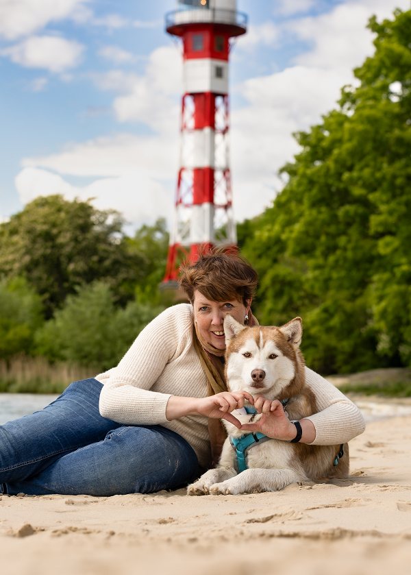 Carmen Hollemann mit ihrem Husky Ashanti am Strand, beide entspannt nebeneinander